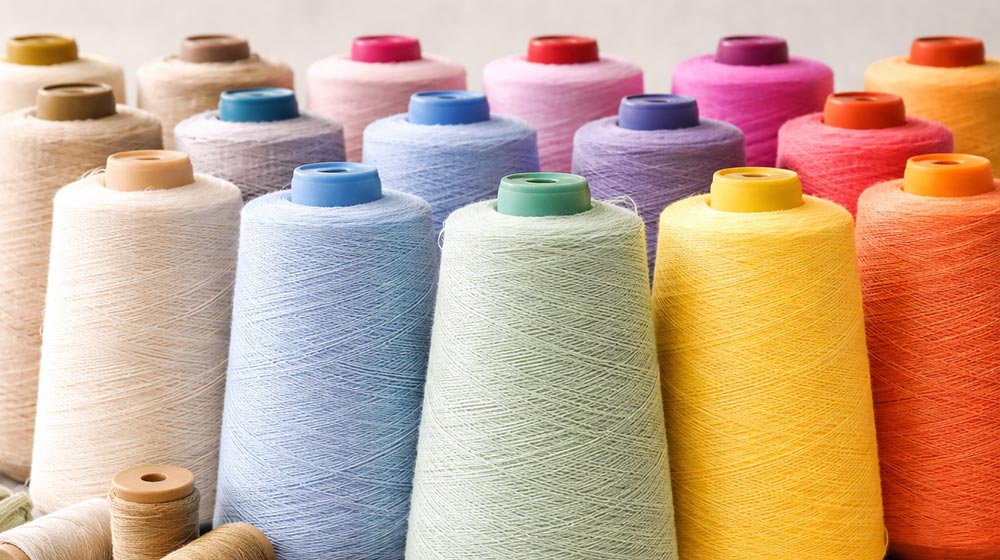 Colorful yarn and thread spools for textile manufacturing, supporting woven and knitted fabric production