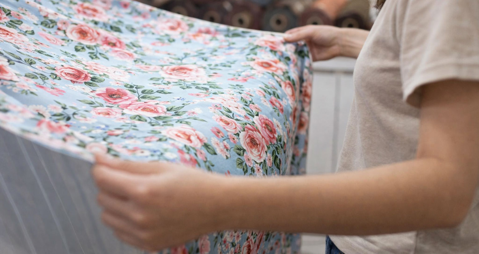 Fabric quality control in production: inspecting floral fabric during manufacturing to ensure sample-bulk consistency.