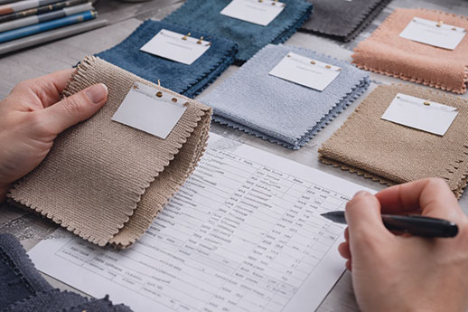 Quality control inspector examining fabric consistency on production list